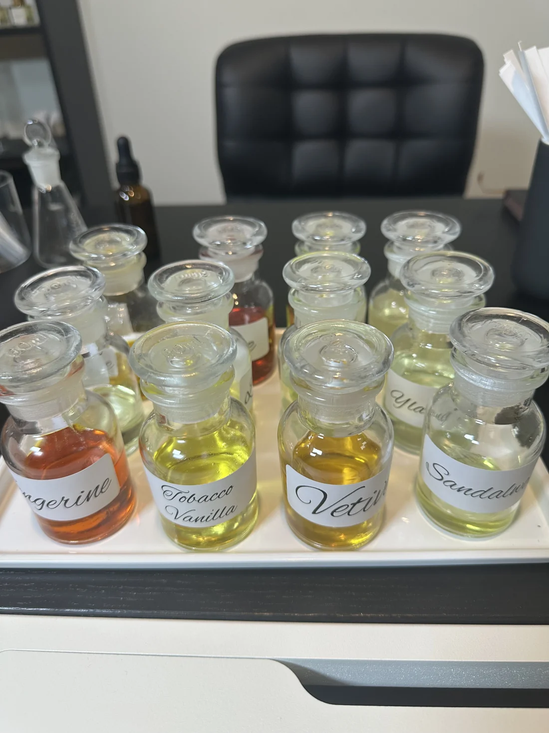 Glass bottles of fragrance materials arranged on the Velum Mystica perfume workbench